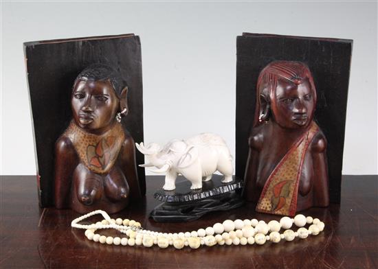 Ivory elephant on stand, a pair of bookends and two ivory bead necklaces